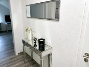 a glass table with a mirror on a wall at Haus Schwarzwald - Bad Krozingen in Bad Krozingen