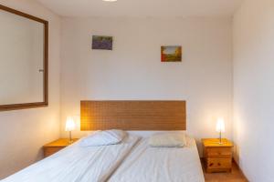 a bedroom with a large white bed with two lamps at Les Sources Gite Cabernet in Chambonas +16 photos