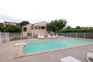 a swimming pool with chairs and a fence at Les Sources Gite Cabernet in Chambonas