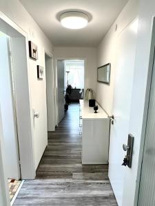 a hallway with white walls and a hallway with a table at Haus Schwarzwald - Bad Krozingen in Bad Krozingen