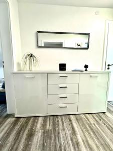 a white dresser in a room with a mirror at Haus Schwarzwald - Bad Krozingen in Bad Krozingen