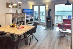 a living room with a dining table and a fireplace at Schleivilla Kapitän James Cook2 in Kappeln