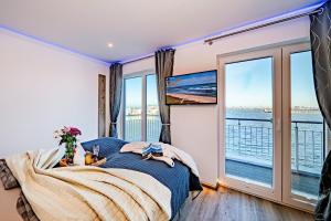 a bedroom with a bed and a large window at Schleivilla Kapitän James Cook2 in Kappeln