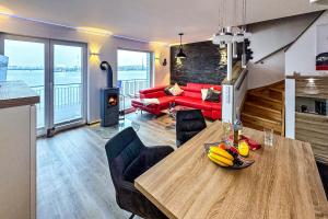 a living room with a table and a red couch at Schleivilla Kapitän James Cook2 in Kappeln
