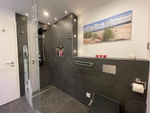 a bathroom with a shower with a painting on the wall at Schleivilla Kapitän James Cook2 in Kappeln +32 photos