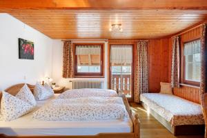 a bedroom with two beds and two windows at Oberes Wirtshaus in Titisee-Neustadt