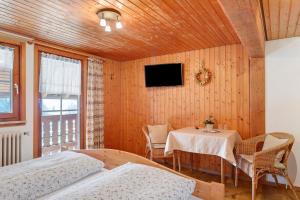 a room with two beds and a table and a tv at Oberes Wirtshaus in Titisee-Neustadt