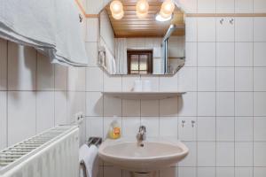 a white bathroom with a sink and a mirror at Oberes Wirtshaus in Titisee-Neustadt +32 photos