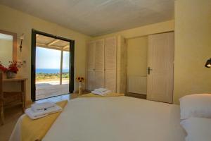 a bedroom with a large bed with a view of the ocean at Villa Mataki Ideales Resort in Kefallonia