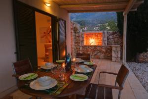 a wooden table with chairs and a tableasteryasteryasteryasteryasteryasteryasteryastery at Villa Mataki Ideales Resort in Kefallonia