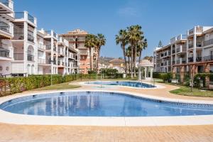 a swimming pool in front of some apartment buildings at Experiencia Marina A107 in Torrox