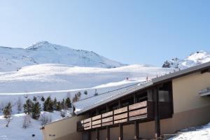 a building with snow covered mountains in the background at Appartement 6 pers Piau Engaly in Aragnouet