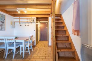 a room with a table and chairs and a staircase at Appartement 6 pers Piau Engaly in Aragnouet +12 photos