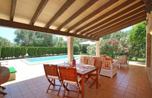 a patio with a table and chairs and a pool at Ca Na Barbara in Santanyi