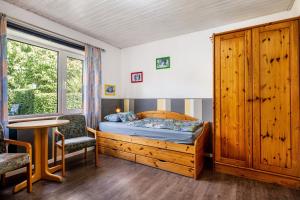 a bedroom with a bed and a table and a window at Ferienwohnung Caspersen in Viöl