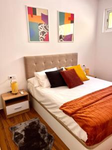 a bedroom with a bed with white sheets and pillows at Amber L5 in Armeñime +5 photos