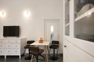 a white room with a table and chairs and a tv at Ferienwohnung Müncheberg 2 in Müncheberg
