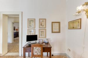 a desk with a computer on a white wall at Luisa in Leuca