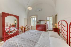 a bedroom with red metal beds and a mirror at Luisa in Leuca