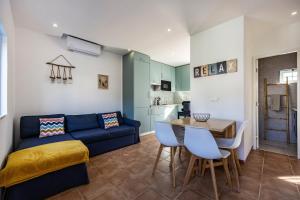 a living room with a blue couch and a table at Salema Beach House in Salema