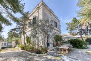 an old stone house with a table and an umbrella at Luisa in Leuca