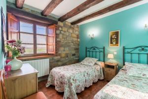 a bedroom with two beds and a window at Apartamento Juntana 1 in Villacarriedo