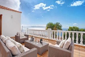 a patio with wicker chairs and tables on a balcony at Casa 1700 Los Quemados in Los Quemados