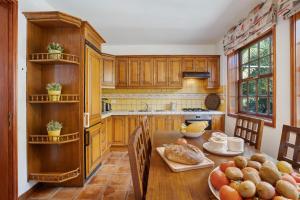 a kitchen with wooden cabinets and a table with food on it at Casa 1700 Los Quemados in Los Quemados