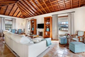 a living room with a white couch and chairs at Casa 1700 Los Quemados in Los Quemados