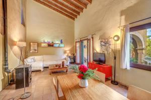 a living room with a couch and a tv at Can Om in Campos