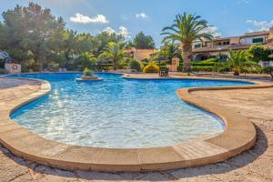 a swimming pool in a resort with palm trees at Can Om in Campos