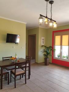 a dining room with a table and chairs and a tv at Zoi apartment in Kefallonia