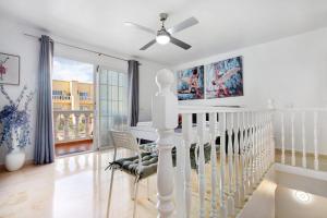 a white dining room with a table and chairs at Sol y Mar Caleta de Fuste in Caleta De Fuste