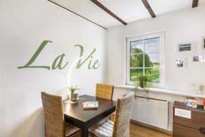 a dining room with a table and chairs with la vie sign on the wall at Ferienhaus Weitblick in Eslohe