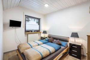 a bedroom with a bed with blue pillows and a tv at Ferienwohnung Familie Süttner in Nagel