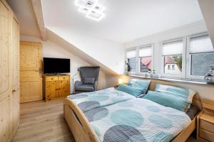 a bedroom with a bed and a tv and windows at Ferienwohnung Familie Süttner in Nagel