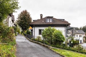 a white house with a fence next to a street at Ferienwohnung Familie Süttner in Nagel
