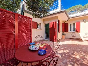 a red table and chairs on a patio at Villa Galatea La Conchiglia in Capoliveri