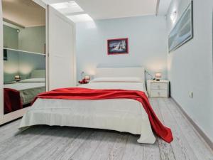 a bedroom with a bed with a red blanket on it at Villa Galatea La Conchiglia in Capoliveri
