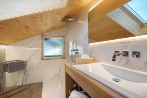 a bathroom with a large white sink and a window at Haus Alpenveilchen - Appartement 4 in Schönau am Königssee +14 photos