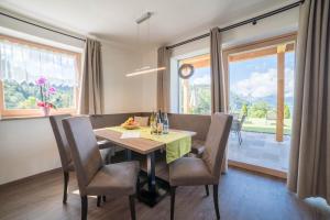 a dining room with a table and chairs and a window at Gasserhof - Chalet B in Meltina