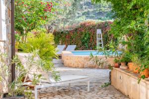 a garden with a swimming pool and flowers at Casa Amber in Sóller