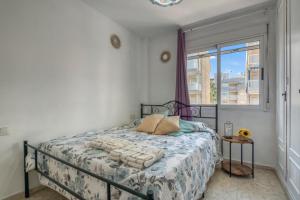 a bedroom with a bed and a window at Apartamento en playa de Daimús in Daimuz +12 photos