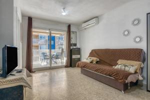 a living room with a couch and a tv at Apartamento en playa de Daimús in Daimuz