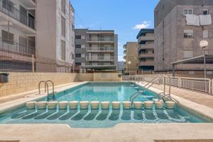 a swimming pool in the middle of a building at Apartamento en playa de Daimús in Daimuz