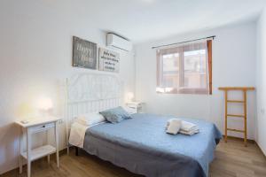 a bedroom with a bed and a desk and a window at Adosado Mareny Blau in Mareny Blau