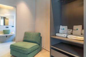 a green chair sitting in a room with towels at Bellini House in Viagrande +49 photos