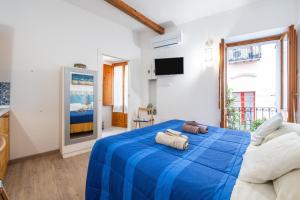 a bedroom with a blue bed with two bags on it at Alla Marina Cagliari in Cagliari