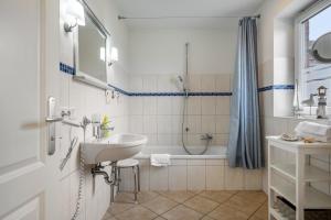 a bathroom with a sink and a bath tub at Haushälfte Süderhafen in Nordstrand +31 photos