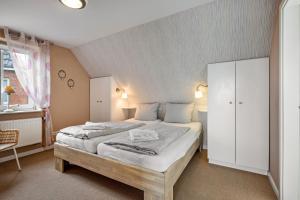 a bedroom with a large bed and a white cabinet at Haushälfte Süderhafen in Nordstrand